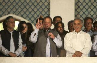 Pakistan Muslim League (N) Leader Nawaz Sharif (centre), flanked by his brother Shahbaz Sharif and daughter Maryam Sharif addresses supporters at a party office in Lahore, after victory